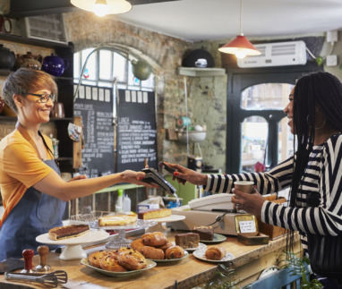 Vrouw betaalt in café voor koffie met haar mobiel
