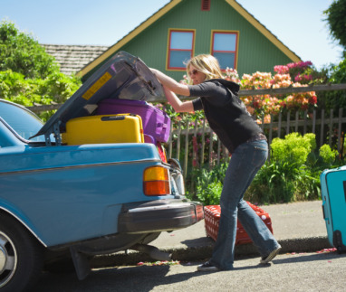 Vrouw laadt kofferbak in met veel te veel bagage