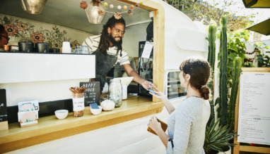 Food truck eigenaar neemt glimlachend creditcard van klant aan