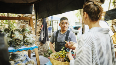 Vrouw koopt groenten bij straatverkoper in Mexico