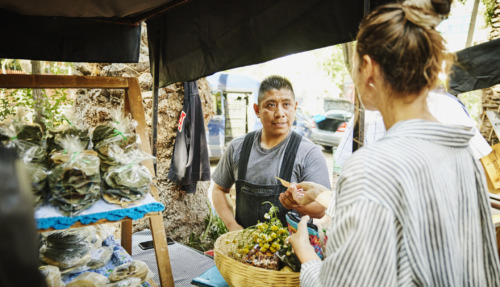 Vrouw koopt groenten bij straatverkoper in Mexico