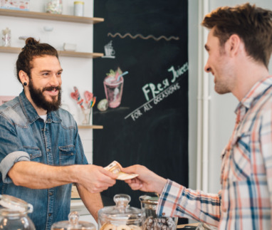 Ober neemt geld aan van klant in een cafe