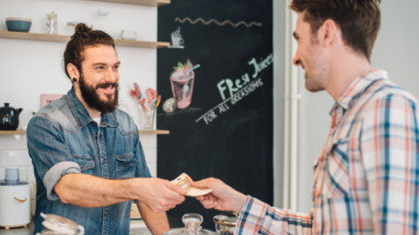 Ober neemt geld aan van klant in een cafe