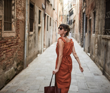 Vrouw wandelt alleen door een sfeervolle steeg in een historische stad