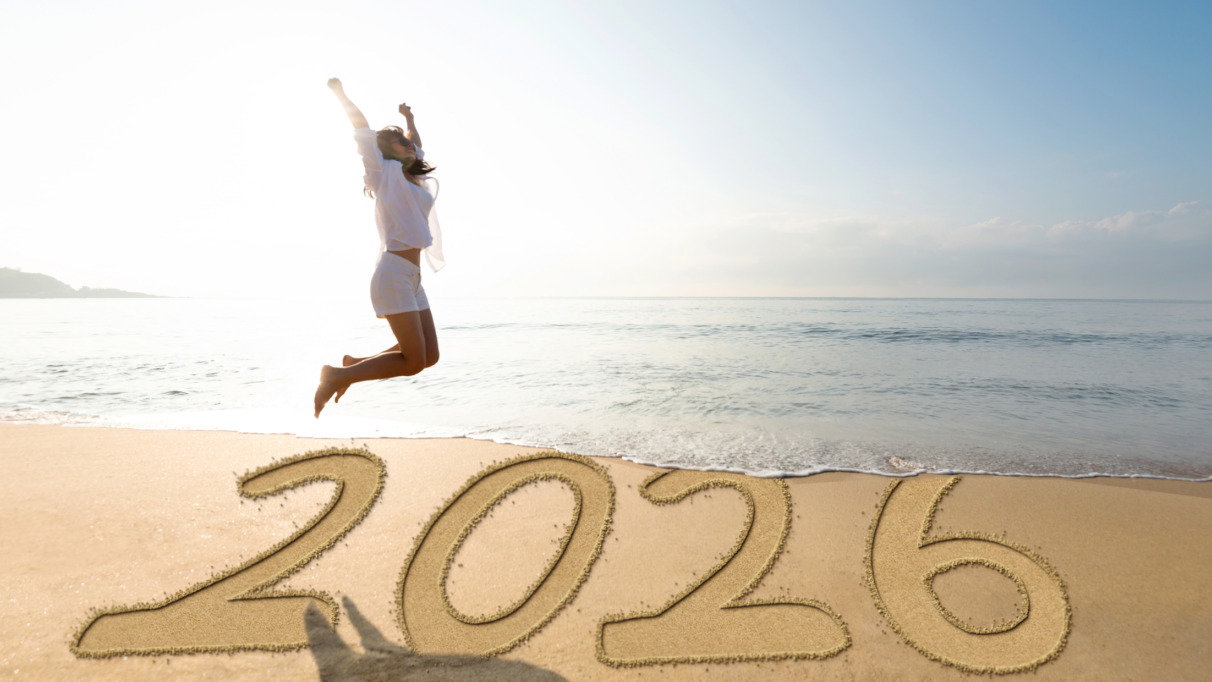 Vrouw springt op het strand voor het nieuwe jaar 2026