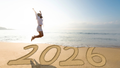 Vrouw springt op het strand voor het nieuwe jaar 2026