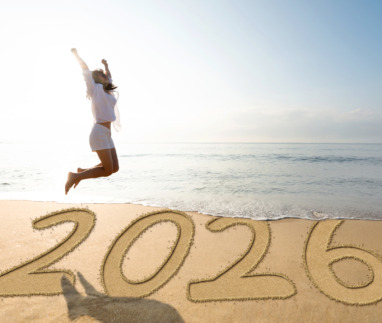 Vrouw springt op het strand voor het nieuwe jaar 2026