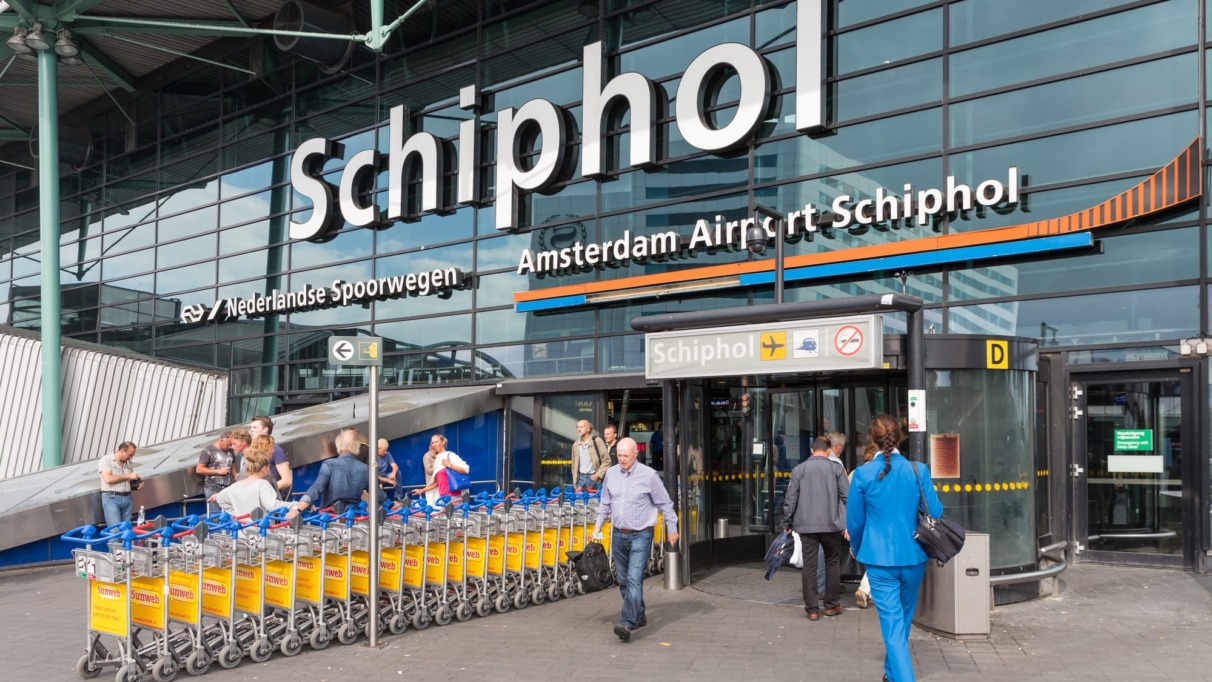 Airport entrance with passing travellers at the airport of Amsterdam