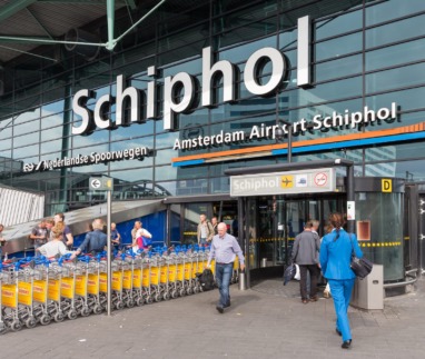 Airport entrance with passing travellers at the airport of Amsterdam