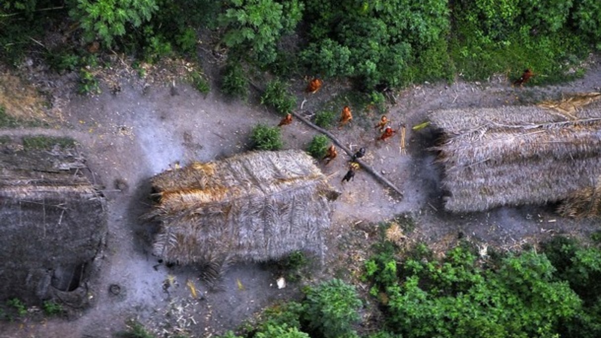 Handout photo shows members of an unknown Amazon Basin tribe and their dwellings during a flight over the Brazilian state of Acre along the border with Peru