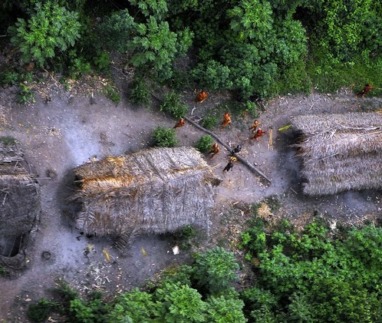 Handout photo shows members of an unknown Amazon Basin tribe and their dwellings during a flight over the Brazilian state of Acre along the border with Peru