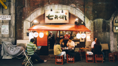 Gezellige Japanse eetkraam onder een spoorbrug n Shinbashi district in Tokio met lokale gasten