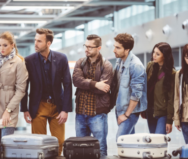 Mensen staan ongeduldig te wachten bij bagageband vliegveld