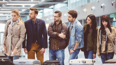 Mensen staan ongeduldig te wachten bij bagageband vliegveld