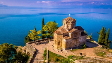 Historische kerk van St. Jovan Kaneo aan het meer van Ohrid, omringd door kristalhelder water en weelderig groen in Noord-Macedonië
