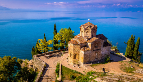 Historische kerk van St. Jovan Kaneo aan het meer van Ohrid, omringd door kristalhelder water en weelderig groen in Noord-Macedonië