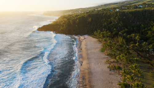 Het idyllische zandstrand Plage de grande Anse omringd door tropisch groen op Réunion.