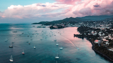 Luchtfoto van de baai van Saint George in Grenada met zeilboten en een kleurrijke zonsondergang