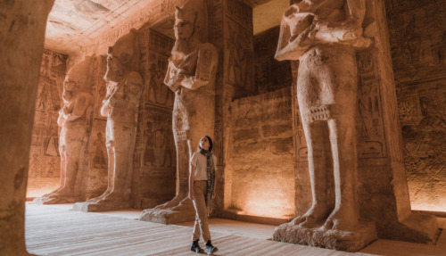 Een reiziger verkent de indrukwekkende beelden in de tempel van Abu Simbel, een van de best bewaarde archeologische schatten van Egypte.