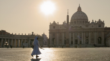 Non wandelend over het Sint-Pietersplein in Vaticaanstad bij zonsopgang, met de iconische Sint-Pietersbasiliek op de achtergrond.