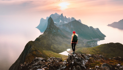 Wandelaars genieten van het uitzicht op de majestueuze fjorden en bergen van Noorwegen bij zonsondergang.