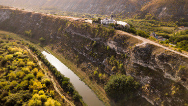 Luchtfoto van klooster Old Orhei (Orhei Vechi) op een klif langs een rivier, omringd door het ongerepte landschap van Moldavië.