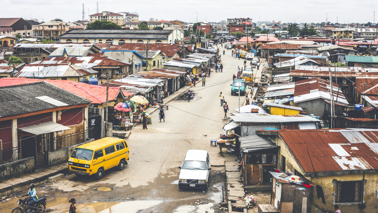Straatbeeld in Lagos, Nigeria met marktkramen, kleurrijke huizen en het dagelijkse leven van de lokale bevolking.