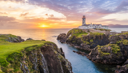Ierland: Vuurtoren op de kliffen van Donegal tijdens een kleurrijke zonsondergang, een perfecte bestemming voor natuurliefhebbers