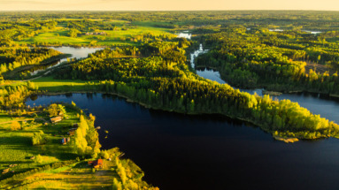 Luchtfoto van Letland met groene bossen, kronkelende rivieren en meren, een typisch voorbeeld van het serene Baltische landschap.