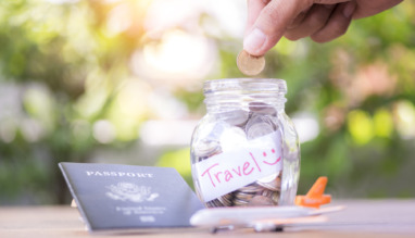 Spaarpot met reisbudget, paspoort en mini-vliegtuig op een tafel