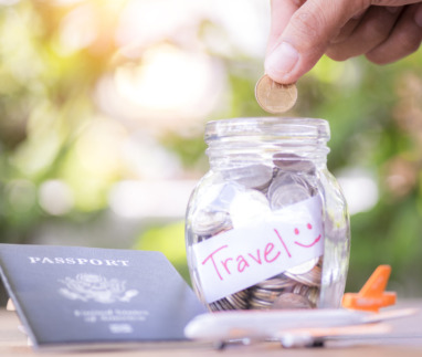 Spaarpot met reisbudget, paspoort en mini-vliegtuig op een tafel