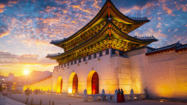 De verlichte Gwanghwamun-poort van het Gyeongbokgung-paleis in Seoul bij zonsondergang.