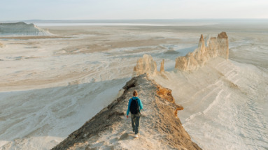 Een wandelaar verkent de adembenemende kalksteenformaties in de eindeloze steppes van Kazachstan.