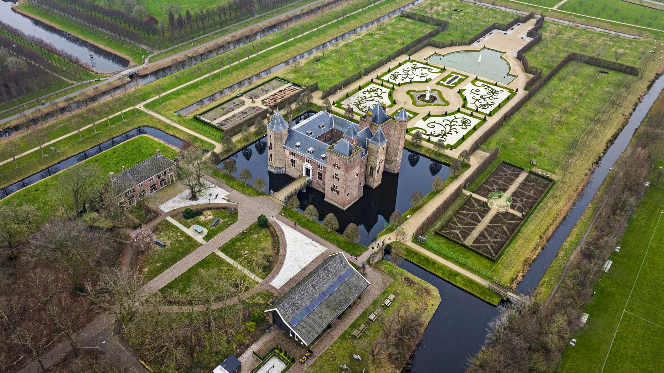 Luchtfoto van Slot Assumburg in Heemskerk, omringd door water en symmetrische kasteeltuinen met sierlijke patronen. Foto: ANP