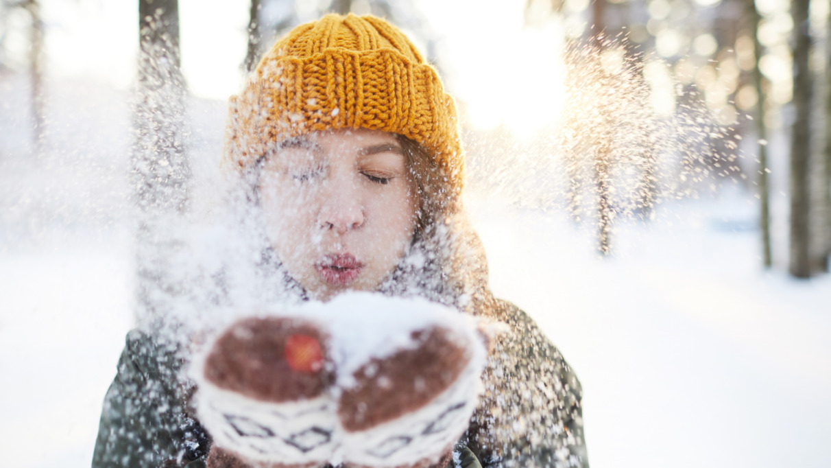 Vrouw blaast sneeuw van handschoenen in Finland