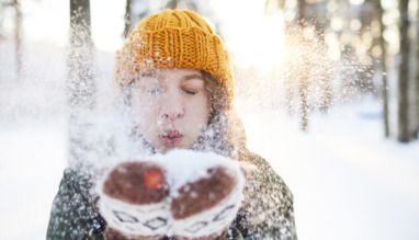 Vrouw blaast sneeuw van handschoenen in Finland