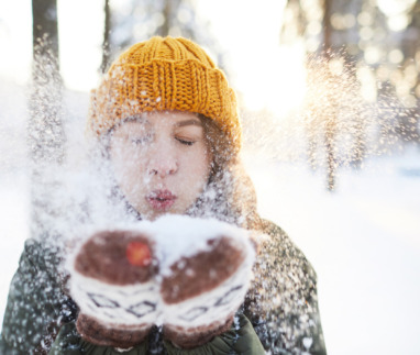 Vrouw blaast sneeuw van handschoenen in Finland
