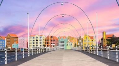 De iconische Koningin Emmabrug met kleurrijke gevels van Willemstad, Curaçao, bij zonsondergang