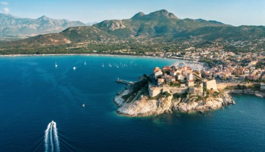 Luchtfoto van Calvi, Corsica, met de citadel, blauwe zee en groene bergen