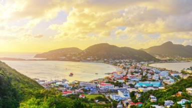 Panoramisch uitzicht op de kustlijn en kleurrijke gebouwen van Sint Maarten bij zonsondergang