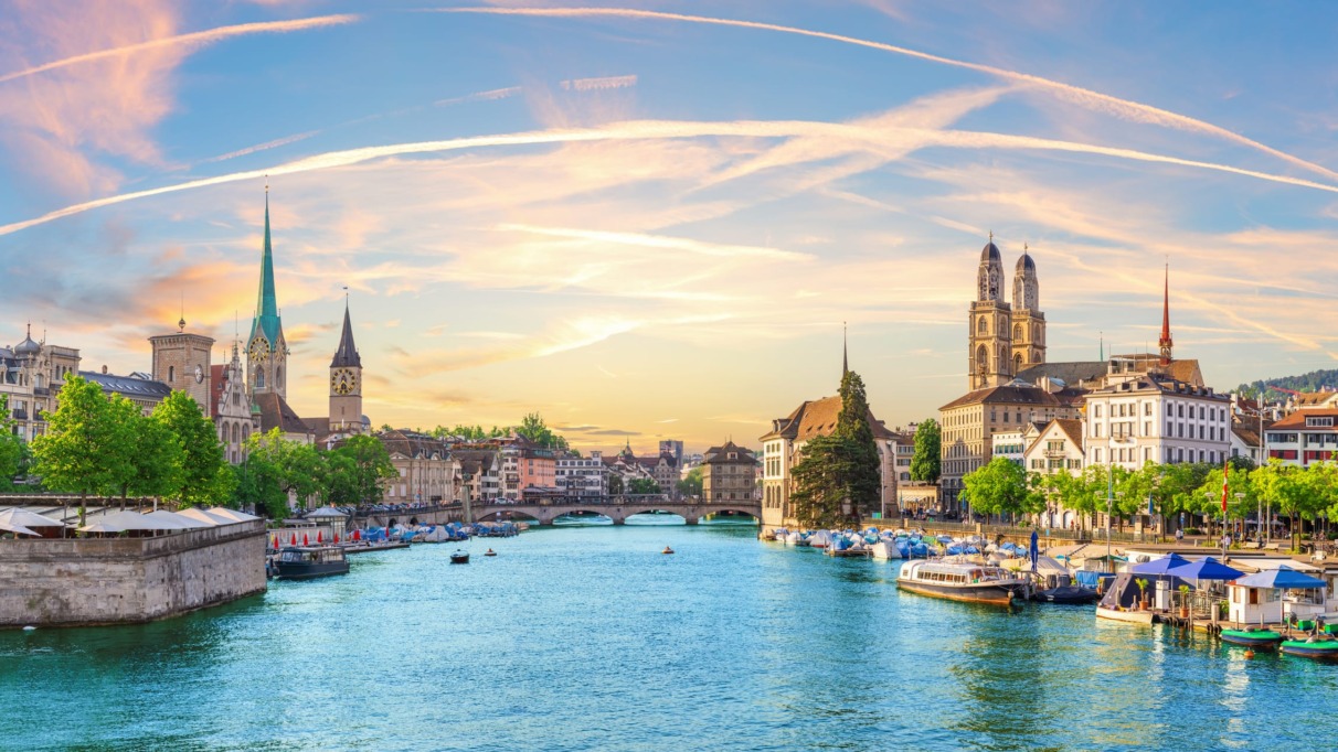 Uitzicht op de rivier de Limmat met de skyline van Zürich bij zonsondergang