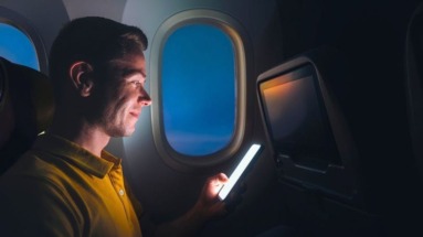 Man kijkt op verlichte telefoon in vliegtuig