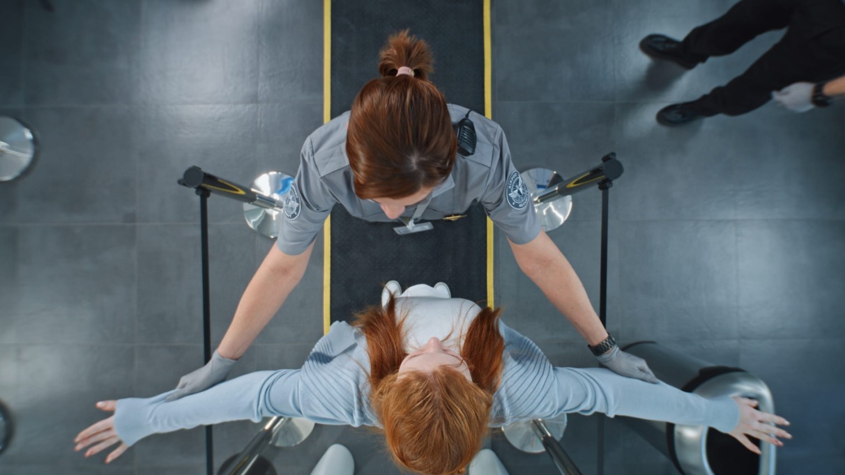 Grensbeambte fouilleert een reiziger tijdens de veiligheidscontrole op een luchthaven
