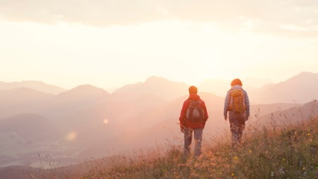 Twee hikers kijken uit over de Unterberghorn in Oostenrijk tijdens zonsondergang