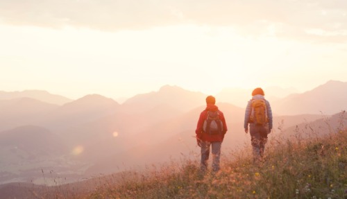 Twee hikers kijken uit over de Unterberghorn in Oostenrijk tijdens zonsondergang