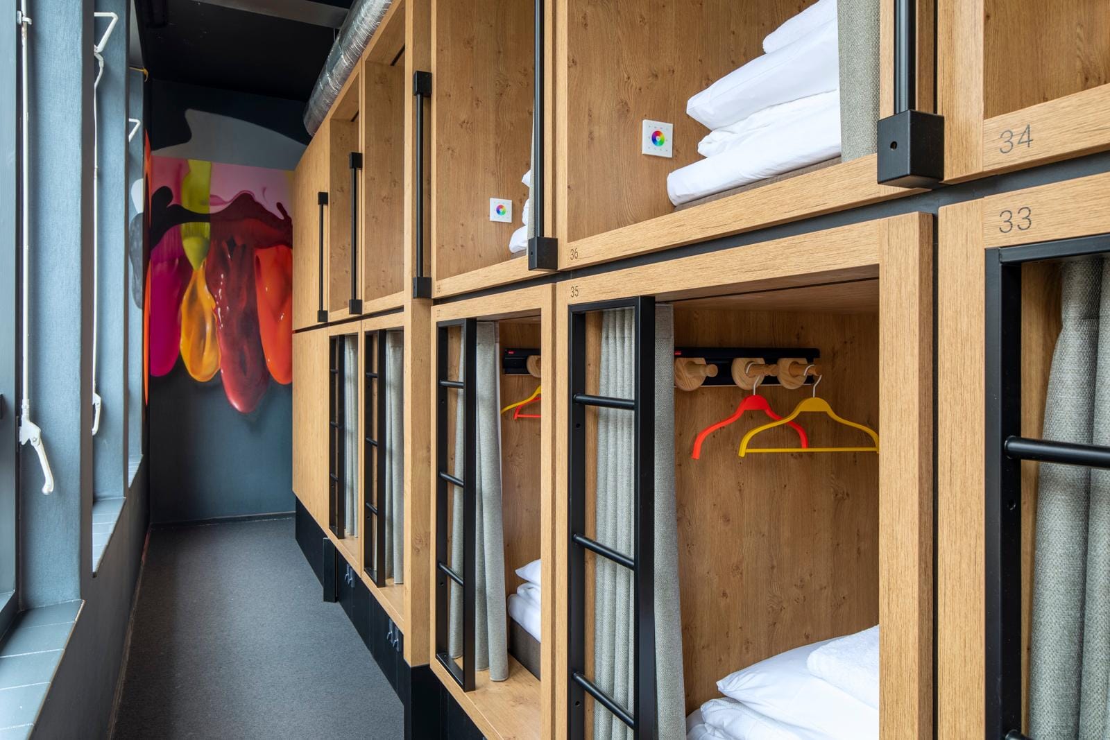 Modern ingerichte slaapcapsules met houten afwerking en kleurrijke details in Hotel Bunk in de voormalige Westerkerk in Utrecht.