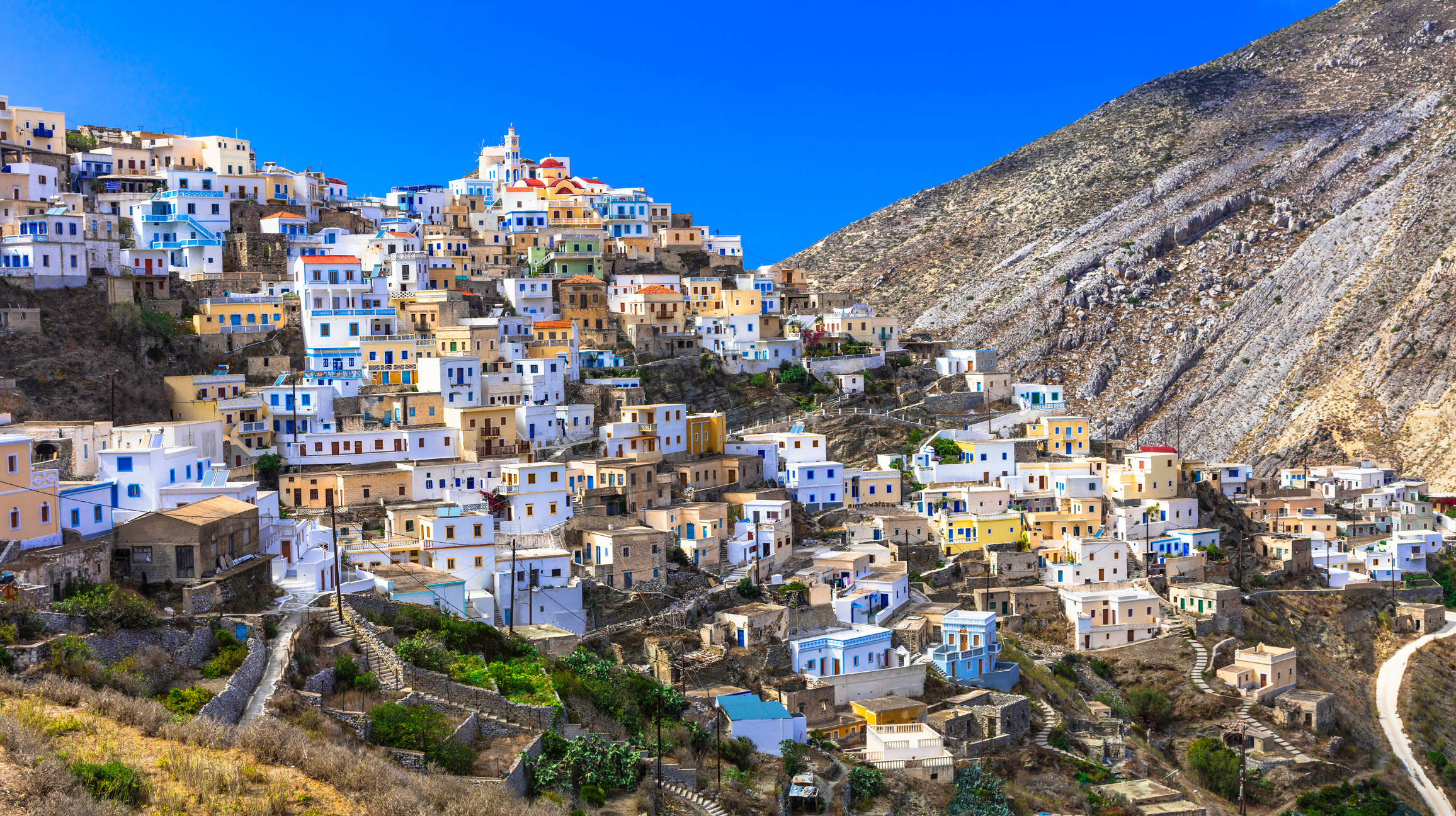 Karpathos is een rauw en puur eiland, met bergdorpen waar tradities nog leven. Olympos is het bekendste voorbeeld, een dorp waar vrouwen traditionele kleding dragen en muilezels nog het hoofdtransport zijn.