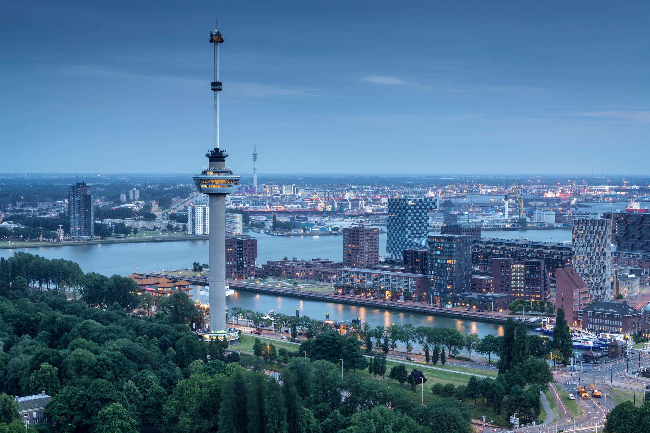 Uitzicht op de Euromast in Rotterdam bij avondlicht, met de skyline en haven op de achtergrond