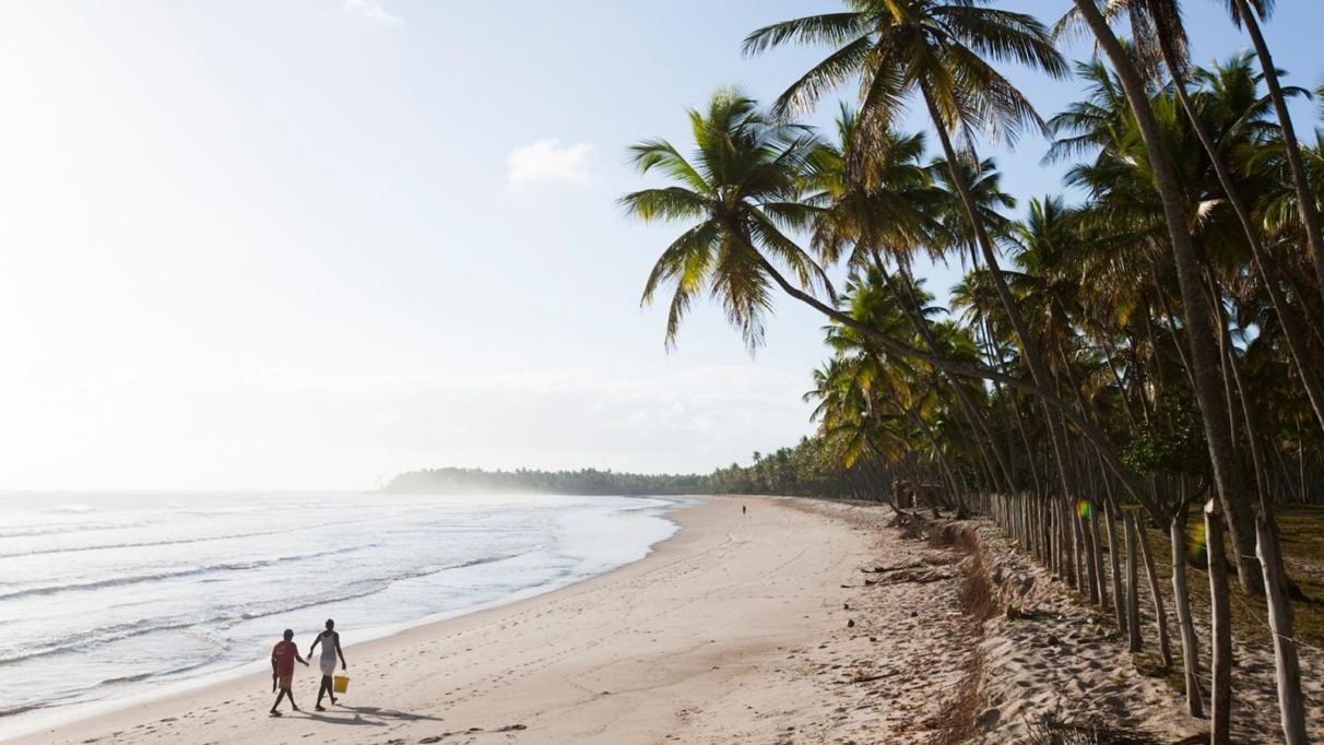 Twee mensen lopen op het strand van Bahia in Brazilië