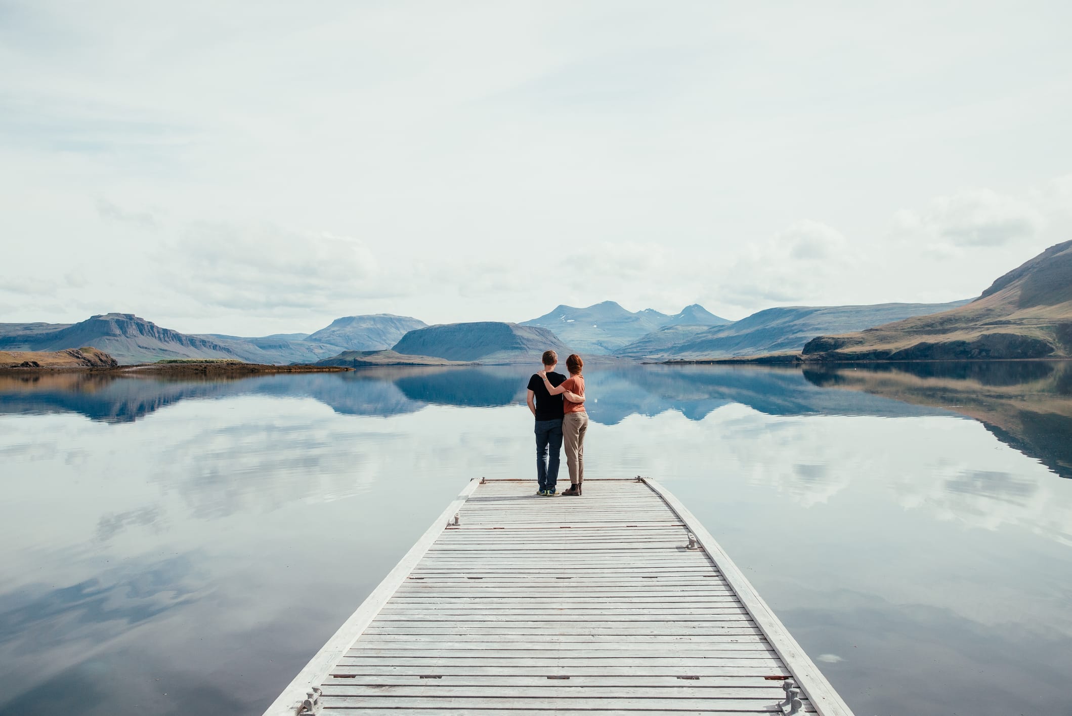 Koppel staat op de steiger van een meer in IJsland, het meest vreedzame land ter wereld in 2025